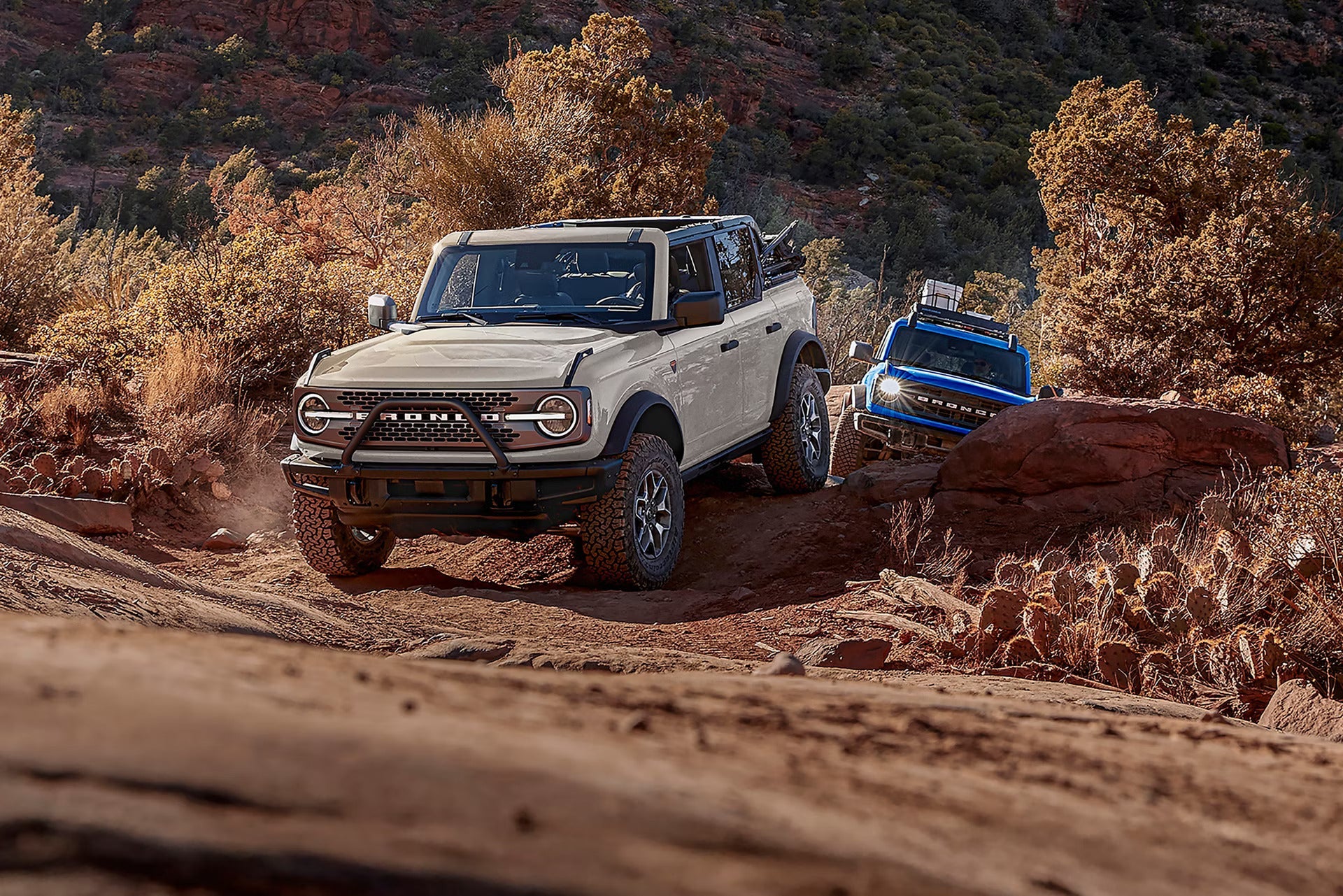 two 2026 ford broncos driving in the desert